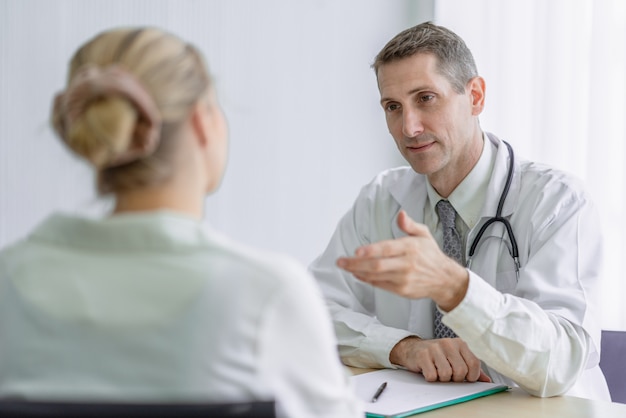 Médecin discutant avec une patiente au bureau de l'hôpital. Concept de médecine et de soins de santé