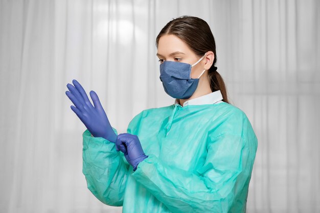 Le médecin à domicile enfile des gants en latex de caoutchouc, protection contre les coronavirus, mesures de sécurité, préparation au travail d'un médecin