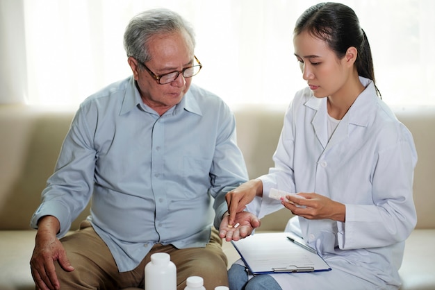 Médecin donnant des pilules à son patient