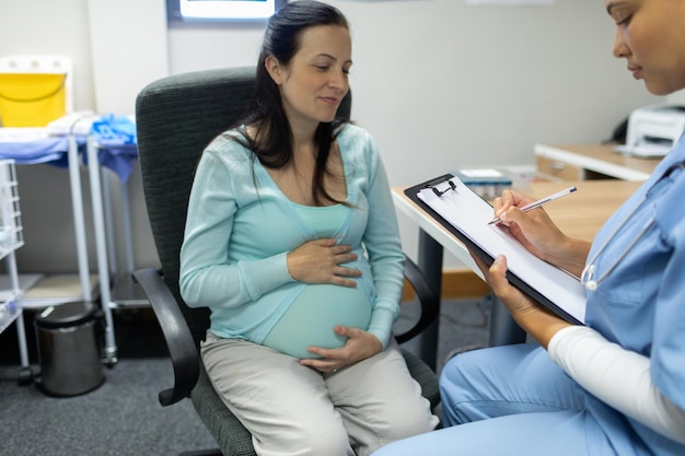 Photo un médecin donne une ordonnance à une femme enceinte à son bureau.