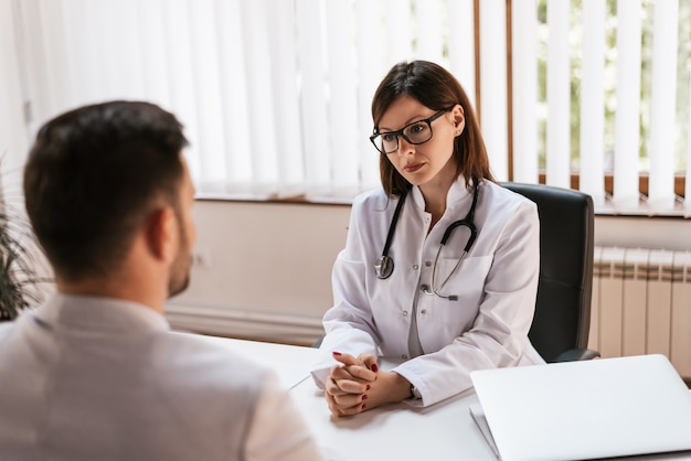 Médecin écoute un patient à son bureau