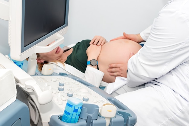 Médecin effectuant une échographie sur une femme enceinte en clinique