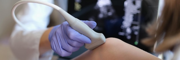 Médecin effectuant un examen échographique de l'articulation du genou chez l'enfant gros plan diagnostic de l'os