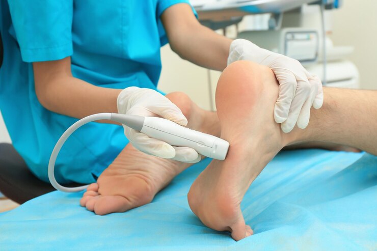 Photo médecin effectuant un examen échographique du pied du patient en clinique