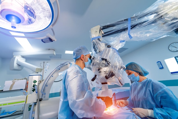 Le médecin effectue un chirurgien peu invasif à l'aide d'un appareil robotique. Innovation neurochirurgicale mini-invasive. Chirurgie robotique médicale avec endoscopie.