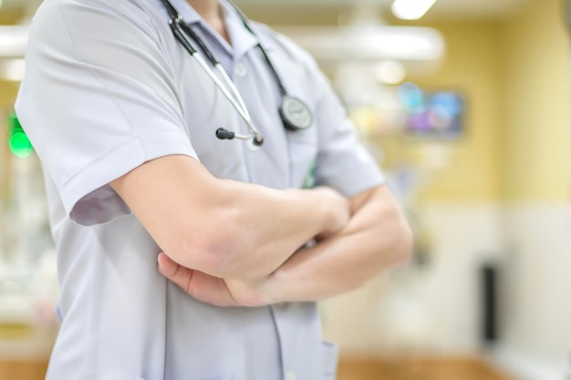 Photo le médecin est debout, les bras croisés, attendant un diagnostic et le traitement d'un patient