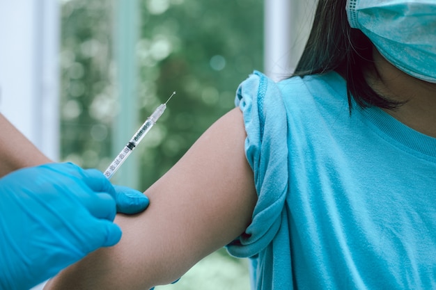 Le médecin est en train de vacciner le patient.