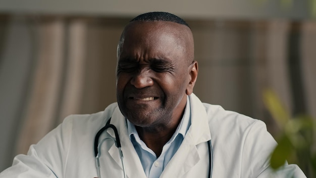 Médecin ethnique africain travailleur médical frotter le mal de gorge souffre d'amygdales enflammées mature malsaine