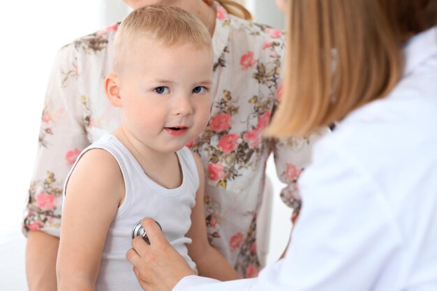 Médecin examinant un enfant patient par stéthoscope