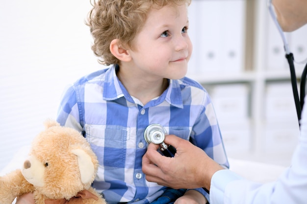 Médecin examinant un enfant patient par stéthoscope