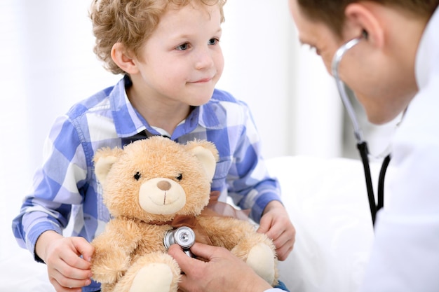 Médecin examinant un enfant patient par stéthoscope