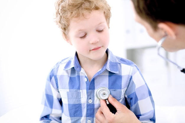 Médecin examinant un enfant patient par stéthoscope