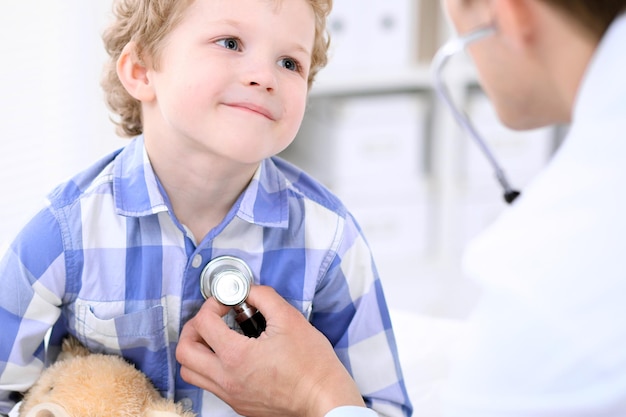 Médecin examinant un enfant patient par stéthoscope