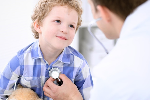 Médecin examinant un enfant patient par stéthoscope