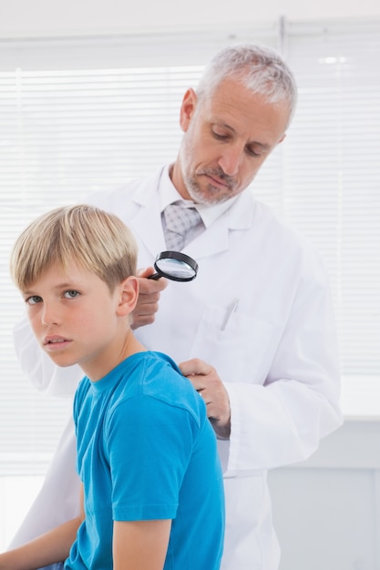 Médecin examinant le patient avec une loupe