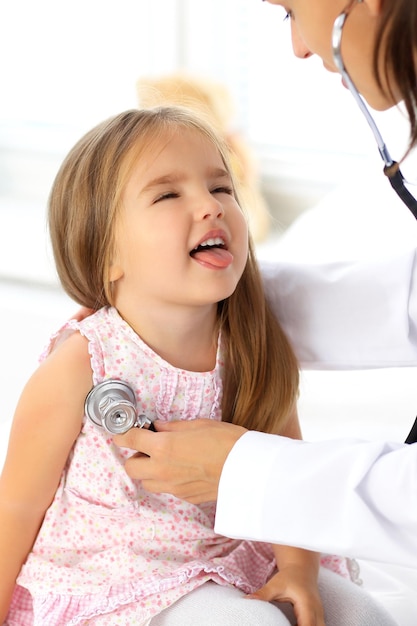 Médecin examinant une petite fille au stéthoscope.