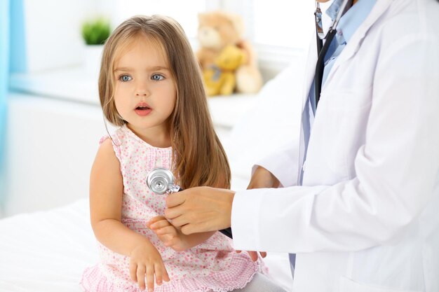 Médecin examinant une petite fille au stéthoscope.