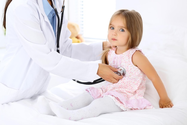 Médecin examinant une petite fille au stéthoscope.
