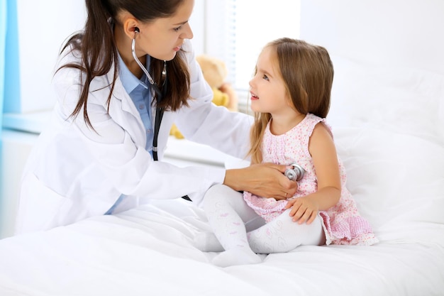 Médecin examinant une petite fille au stéthoscope.