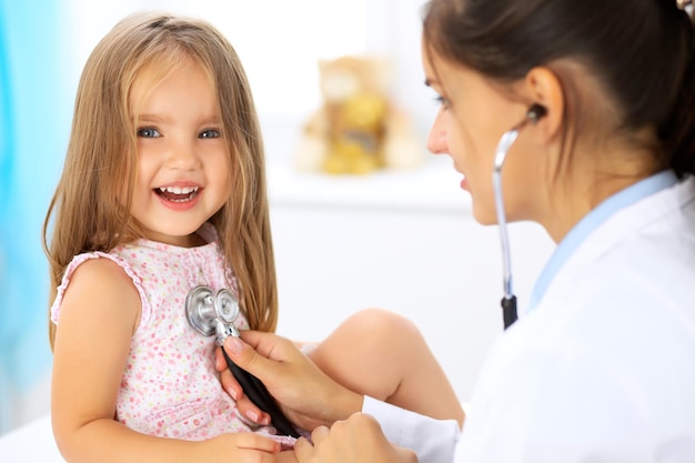 Médecin examinant une petite fille au stéthoscope.