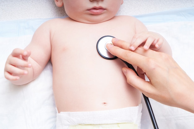 Le Médecin Examine Le Bébé Avec Un Stéthoscope. écoute Le Cœur