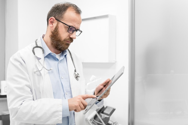 Un médecin examine une image radiographique d'un patient sur une tablette numérique au cabinet du médecin