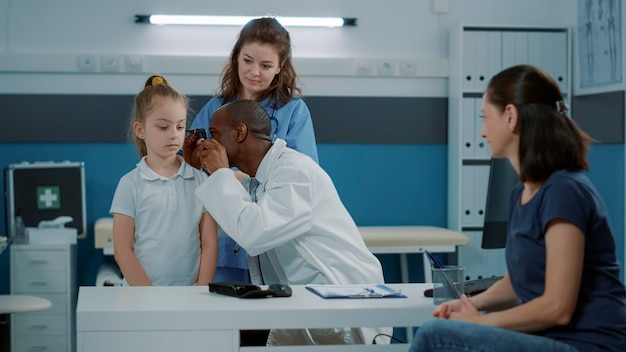 Le médecin examine l'oreille du patient