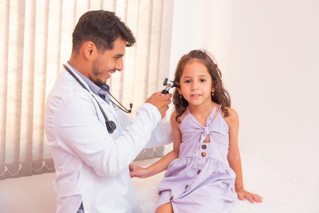 Le médecin examine l'oreille avec un otoscope dans une chambre de pédiatre. Équipement médical