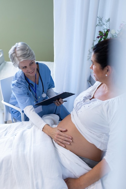 Photo une médecin examine le ventre d'une femme enceinte dans un service.