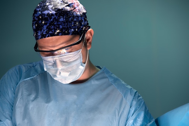 Médecin exécutant une intervention chirurgicale dans une salle d'opération sombre avec lampe sur fond