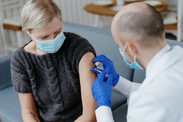 Médecin expérimenté vaccinant une femme mûre concept de vaccination