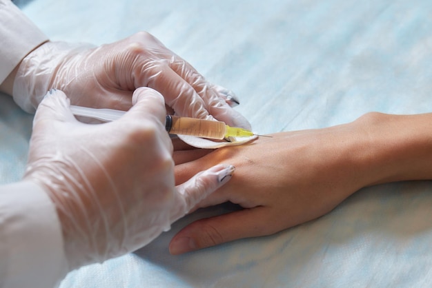 Médecin faisant une thérapie par cellules souches sur le coude d'un patient après la blessure traitant la douleur au genou avec des plaquettes