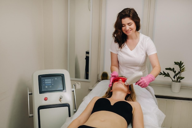 Un médecin fait une épilation au laser pour un client de poils faciaux indésirables dans un salon de beauté