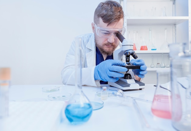 Un médecin fait un test ADN avec des échantillons en laboratoire en regardant un microscope