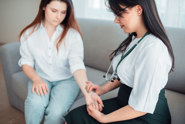 Médecin de famille contrôle la fréquence cardiaque d'une jeune mère