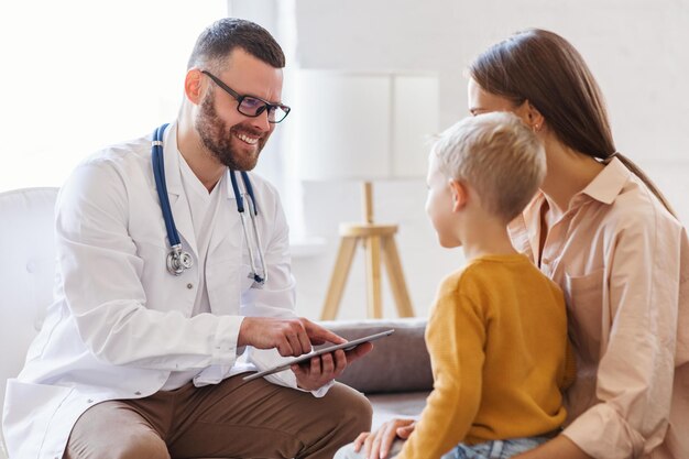Un médecin de famille pédiatre procède à l'examen d'un enfant garçon qui est venu avec sa mère