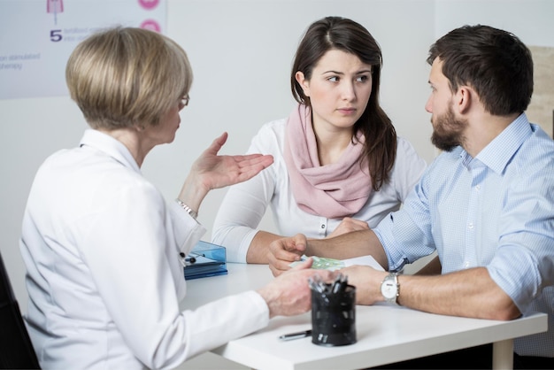 Un médecin et une femme discutent avec un médecin.