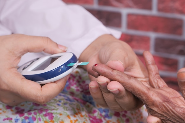 Médecin de femmes mesurant le diabète des femmes âgées.