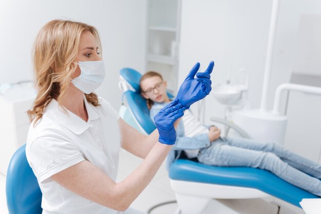 Un médecin formé assez précis met ses gants médicaux pour s'assurer que tout est propre et stérile