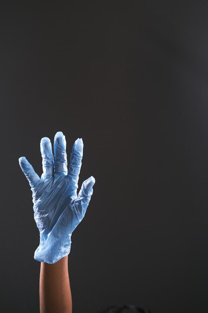 Photo médecin avec des gants médicaux isolé sur noir