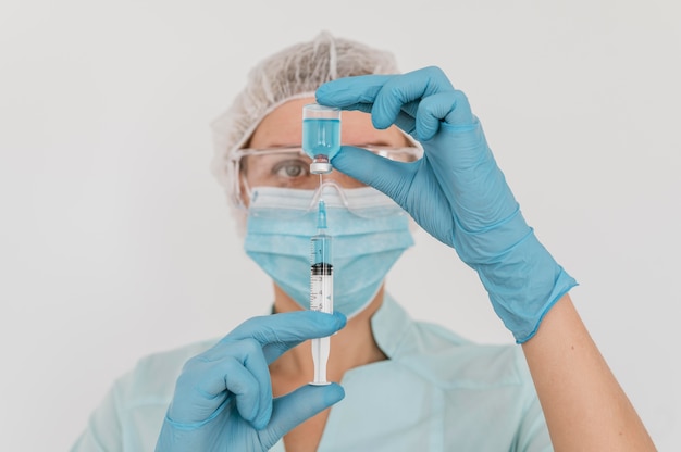 Photo médecin avec des gants tenant le vaccin et la seringue