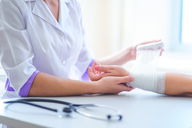 Photo médecin général bandage le poignet du patient à l'hôpital