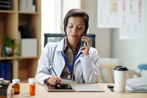 Médecin généraliste parlant au téléphone