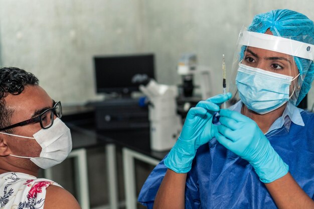 Médecin hispanique administrant une injection à un patient