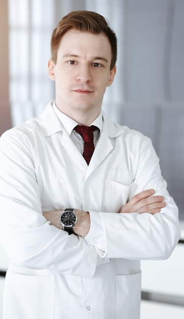 Médecin homme headshot alors qu'il se tenait dans le bureau de l'hôpital Médecin sur le lieu de travail photo portrait Concept de médecine et de soins de santé