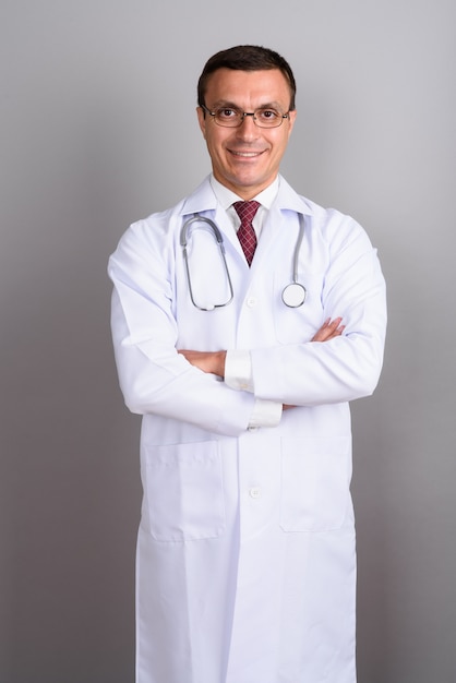 Médecin homme portant des lunettes contre le mur gris