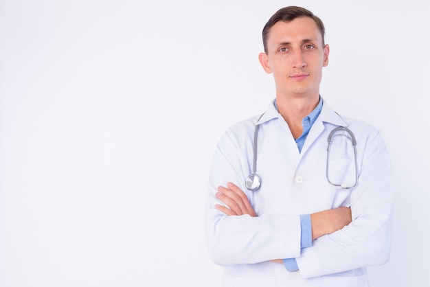 Médecin homme avec stéthoscope autour du cou isolé contre le mur blanc