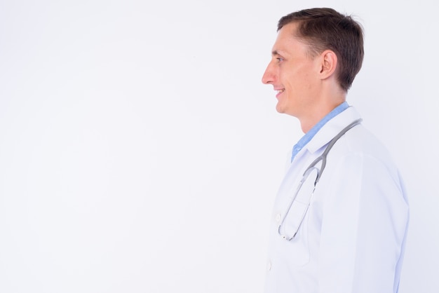 Médecin homme avec stéthoscope autour du cou isolé contre le mur blanc