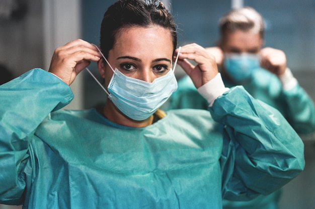 Un médecin et une infirmière se préparent à travailler à l'hôpital pour une opération chirurgicale lors d'une épidémie de pandémie de coronavirus