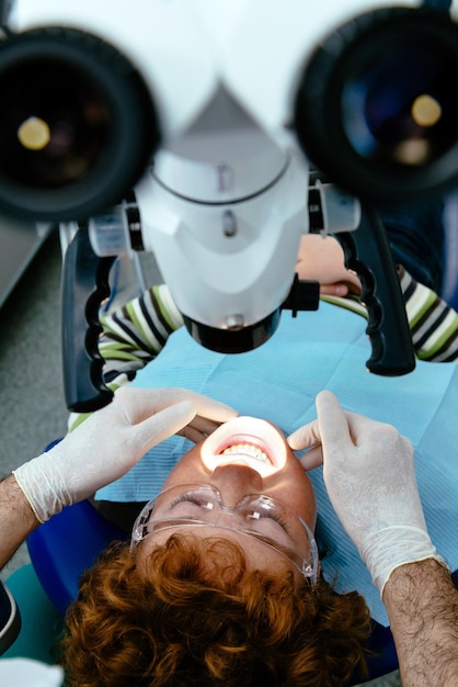 Photo le médecin inspecte les dents de bébé avec un microscope